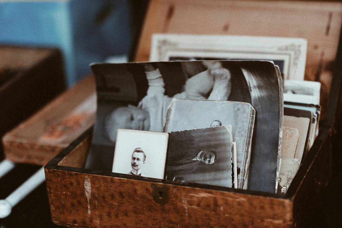 Handcrafted keepsake memory boxes wood with visible grain and brass hinges, displayed open with vintage photos inside